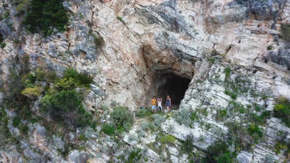 group of tourists in a cave on the rocky cliff on the coast of Himare, Albania. Aerial reversing