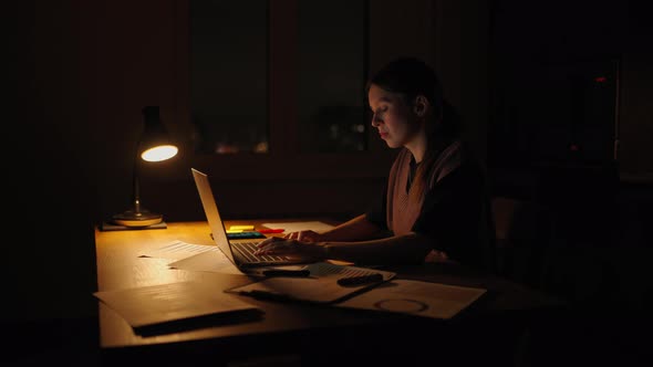 Young Good Looking Caucasian Woman Typing and Working on the Laptop Computer As Freelancer While