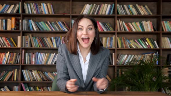 Successful Businesswoman Raises Hands in Happiness at Table