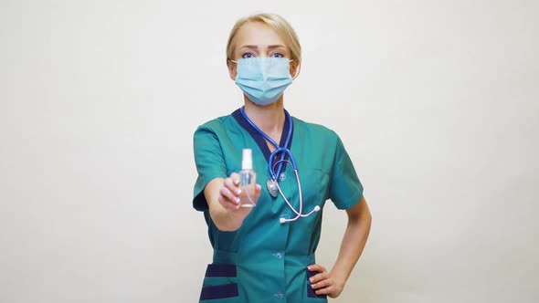 Medical Doctor Nurse Wearing Protective Mask - Holding Bottle of Sanitizing Spray or Gel