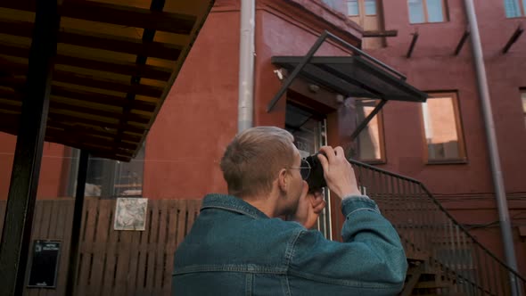 A Young Traveller Takes Pictures of a Red Brick Building in an Old Town