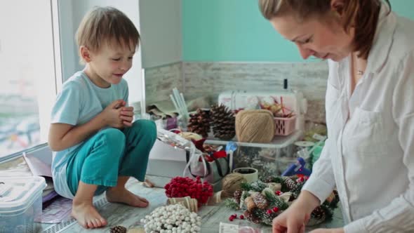 A Girl and a Child Collect a Christmas Wreath Together