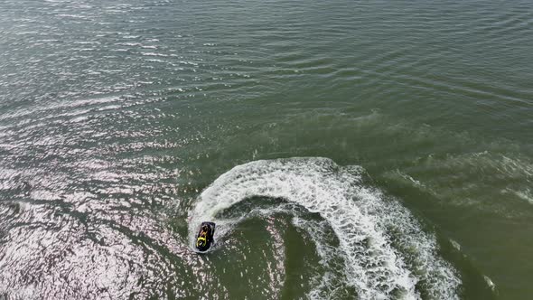 An aerial view over Gravesend Bay in Brooklyn, NY as a jet ski rider enjoys the sunny day. The drone