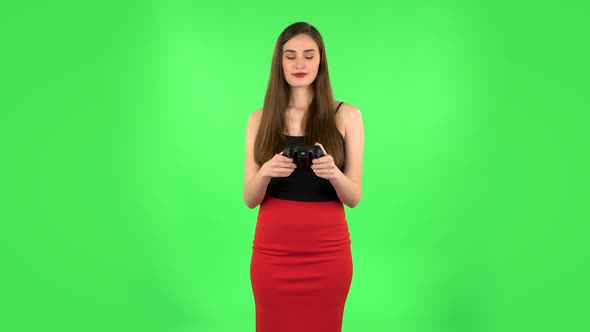 Girl Playing a Video Game Using Wireless Controller. Green Screen