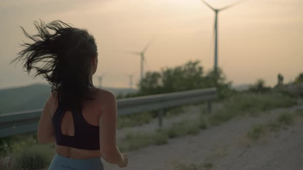 Athletic Girl Jogging in the Mountains at Sunset