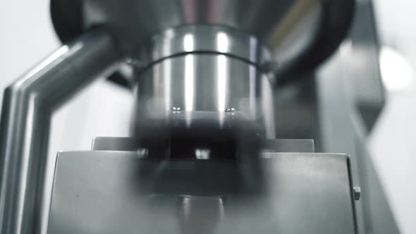 Automated machinery on a medicine factory producing pharmaceutical medicine tablet pills, close up