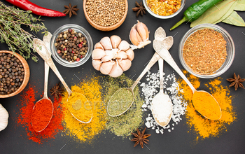 A variety of spices and herbs on a dark table. Ingredients for cooking. Table background menu.