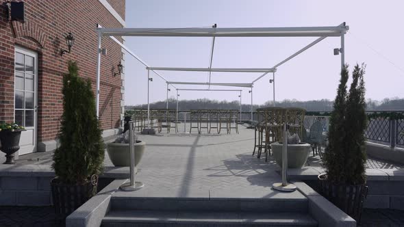 Wide Shot of Hotel Terrace in Sunshine with Chairs Standing Outdoors