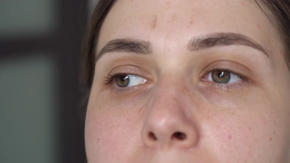 Gloved Hands Closeup Plucking Hairs on the Eyebrows with Tweezers