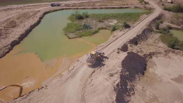 Excavator Driving Within Sand Quarry