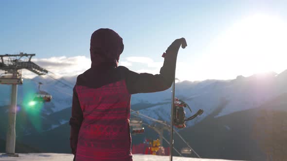 Girl Snowboarder with Snowboard on Mountain Top on Ski Resort.