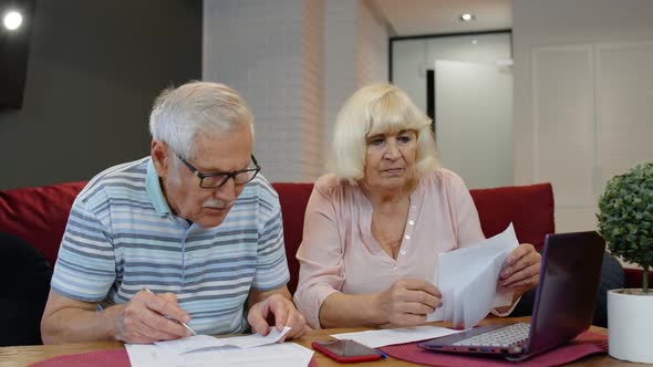 Senior Old Couple Stressed About Paperwork Discuss Unpaid Bank Debt Holding Bills Check Expenses