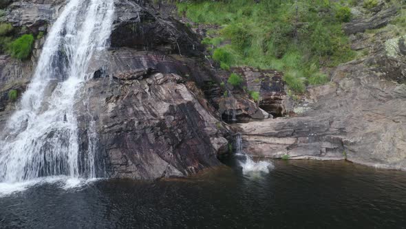 Man swimming drone aerial view in most beautiful waterfall Fisgas de Ermelo, Portugal