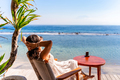 Young woman traveler relaxing and enjoying the beach view while traveling for summer vacation - PhotoDune Item for Sale