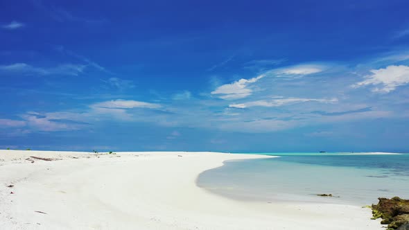 Wide angle fly over clean view of a white sand paradise beach and aqua blue ocean background in hi r