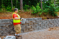 Construction worker mounting concrete block was perfectly aligned on the retaining wall. - PhotoDune Item for Sale