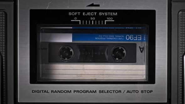 Audio Cassette Tape Rotates in Deck of an Old Tape Recorder