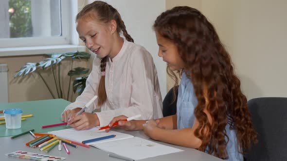 Two School Friends Talking While Drawing Together at Art Class Lesson