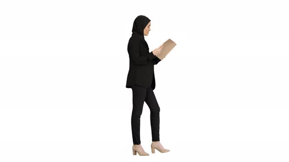 Surprised Muslim Businesswoman Reading Business Diary and Shaking Her Head While Walking on White