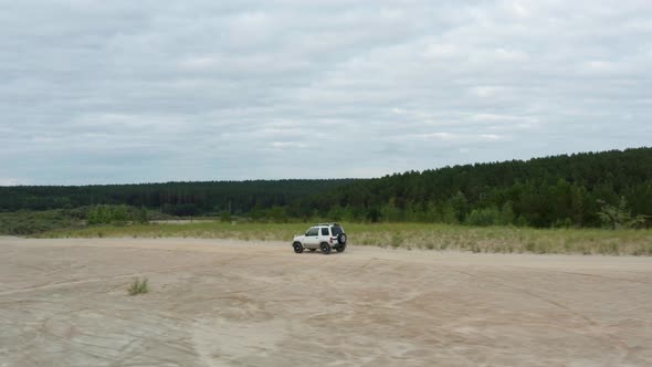 Aerial View of a Car Driving on Sand