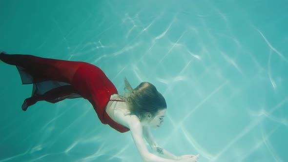 Magical Underwater Shot of a Young Woman Swimming Underwater