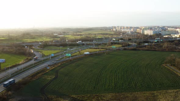 Aerial Shot of Transport Infrastructure with Cars and City in Background During Winter on Sunny Day