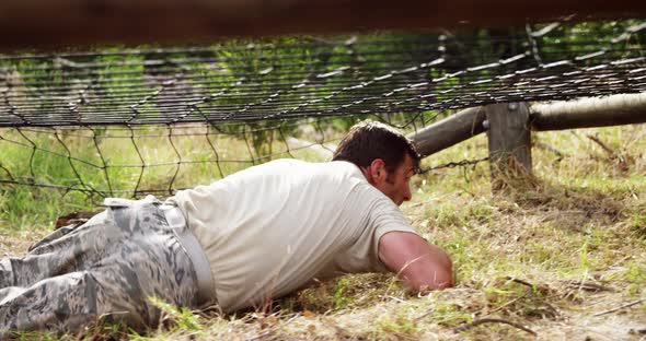 Military soldier crawling under the net during obstacle course 4k