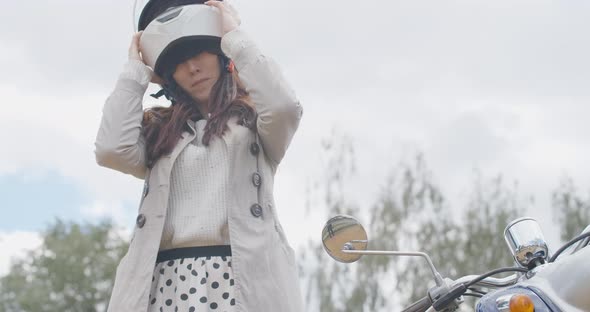 Confident Female Biker Taking Off Helmet in Slow Motion. Portrait of Beautiful Young Caucasian