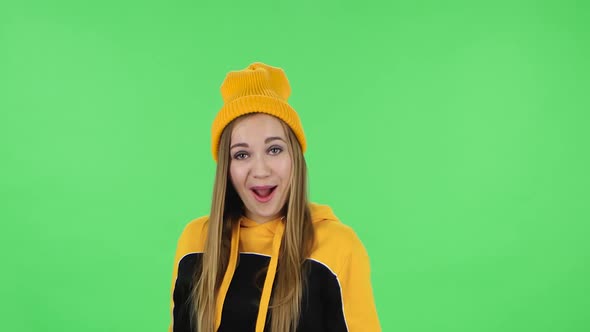 Portrait of Modern Girl in Yellow Hat Is Laughing . Green Screen