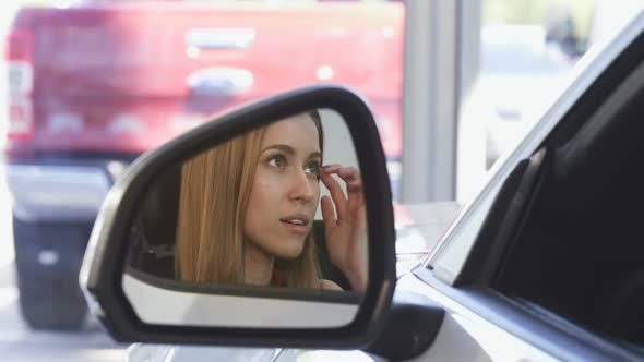 Beautiful Female Driver Smiling To the Camera in the Side Mirror