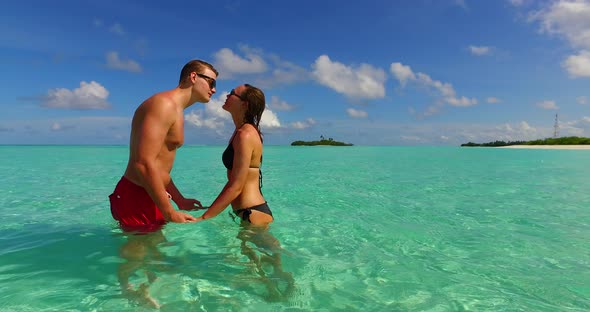 Beautiful couple in love dating on vacation live the dream on beach on summer white sandy
