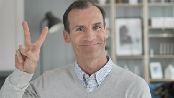 Victory Sign by Positive Middle Aged Man