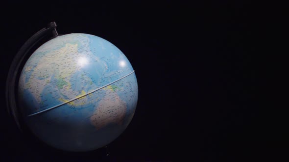 The globe rotates on a black background. Globe spinning on black screen. Slow motion	