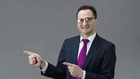 Happy Handsome Adult Businessman Pointing with Hands To Left Side, Text Space
