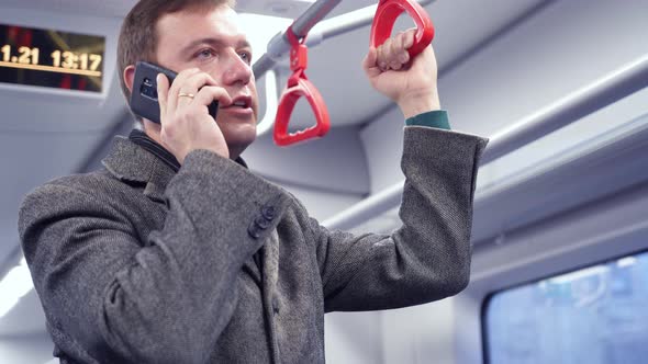 Millennial Man Making Phone Call in Subway Train