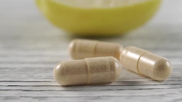 Capsules with mineral supplements and vitamins on a wooden background. 