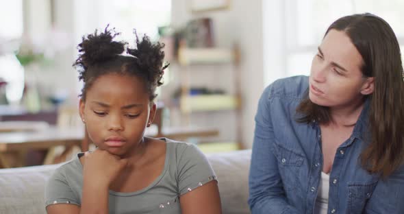 Caucasian woman arguing with her african american daughter in living room