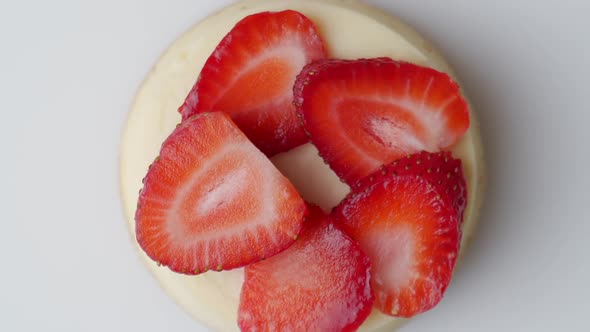 Cheesecake with Strawberries Rotates on a White Background