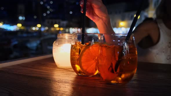 Woman Drinking Aperol Spritz Cocktail Sitting at Summer Cafe Terrace in the Evening at Hydra Greece