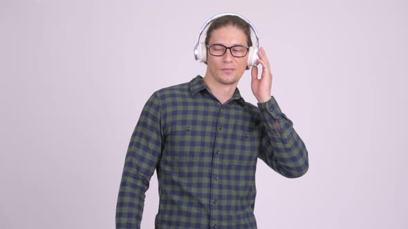 Handsome Hipster Man Wearing Headphones and Listening To Music