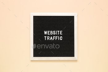The phrase website traffic on black letter board over isolated beige background