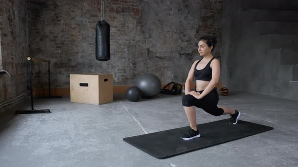 Flexible woman stretching legs in fitness club. Sporty woman training stretch exercise for legs 