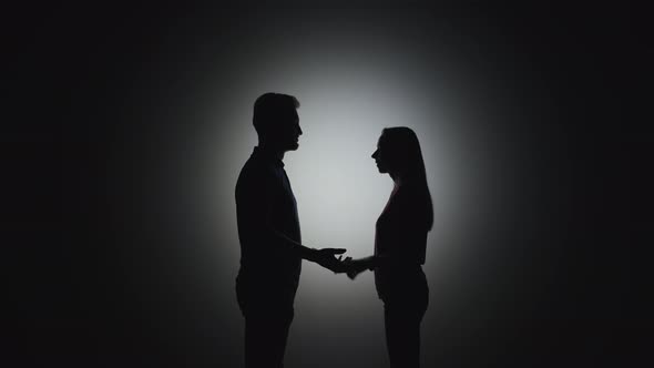 Silhouettes of Man and Woman Holding Hands