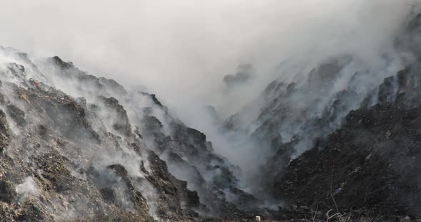 Close up of landfill with burning trash piles