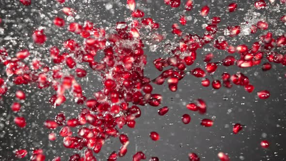 Super Slow Motion Shot of Fresh Pomegranate Seeds and Water Side Collision at 1000Fps.