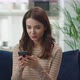 Attractive Happy Young Woman is Using Smart Phone at Home Getting Good News - VideoHive Item for Sale