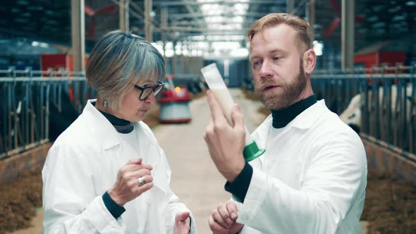 Two Farm Specialists are Discussing a Sample of Raw Milk