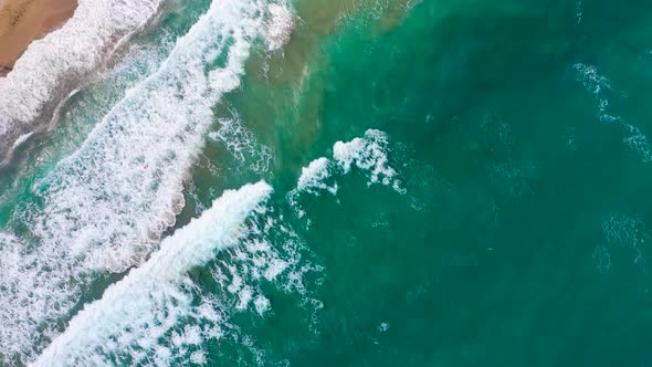 Aerial View of the Mediterranean Coast Waves Reach the Deserted Sandy Beach