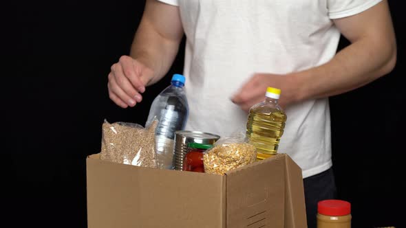 Volunteer Putting Food in a Donation Box. Charity Concept