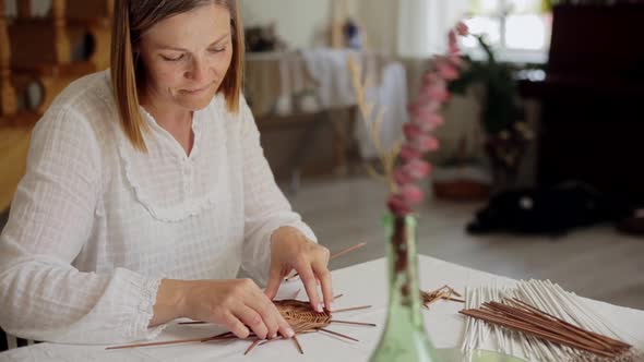 Mature Woman Making Paper Vine Basket at Home